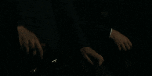 a man and woman are looking at each other in the dark