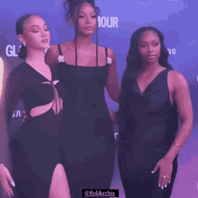 three women are posing for a picture in front of a wall that says glamour
