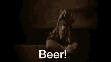 a bottle of beer is being poured into a glass in a dark room and the words beer are coming out of it .
