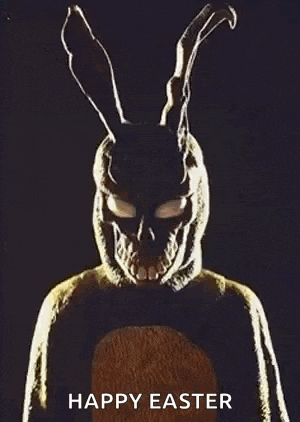 a person in a bunny costume with a skull on their face is standing in the dark .