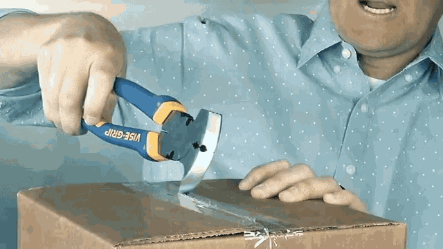 a man is using a pair of wise grip pliers on a cardboard box