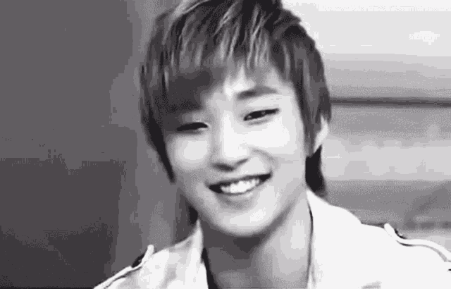 a black and white photo of a young asian man smiling .