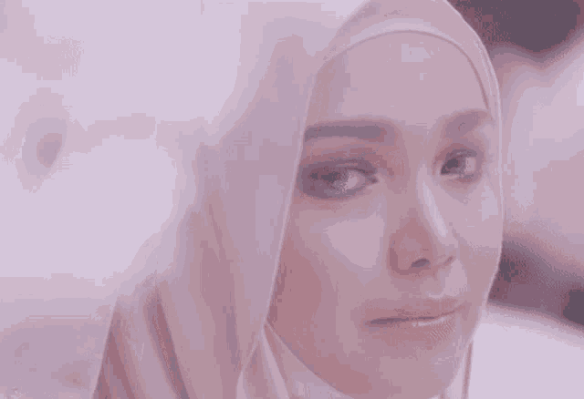 a close up of a woman wearing a hijab looking at the camera