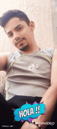a man wearing a gray tank top with the word hola on it