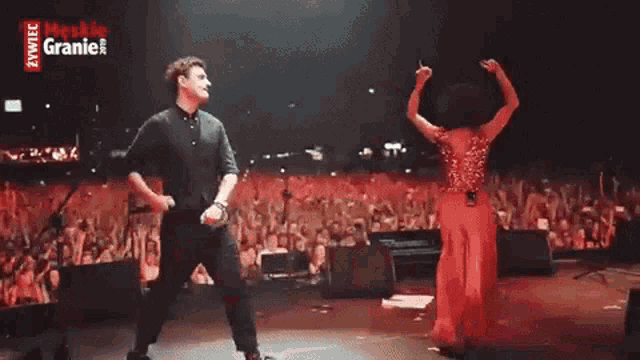 a man and a woman are dancing on a stage with a sign that says meskie granie on it
