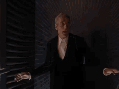 a man in a suit and tie is standing next to a railing and saying `` fuck yes ya dancer '' .