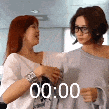 two women standing next to each other with the time 00:00 on the bottom right
