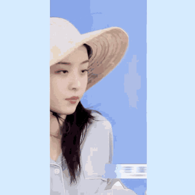 a close up of a woman wearing a straw hat on a blue background
