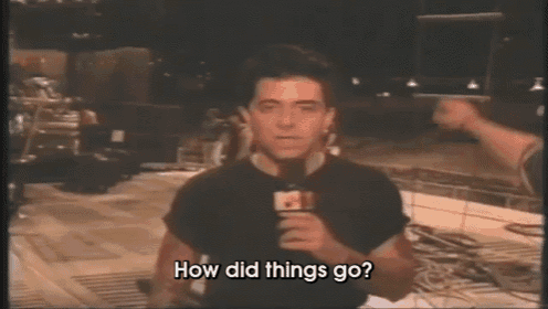 a man in a black shirt is holding a microphone and asking how did things go .