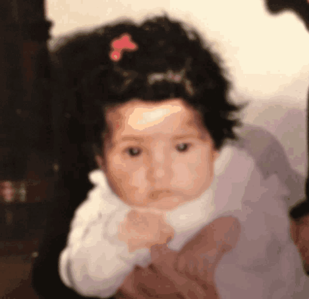 a baby with a pink bow in her hair