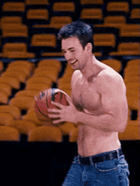 a shirtless man is holding a basketball in his hands