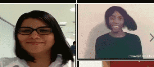 a woman wearing glasses and a green shirt is smiling in a video call