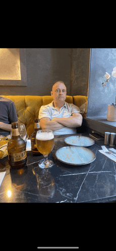 a man sits at a table with a bottle of scotch whisky