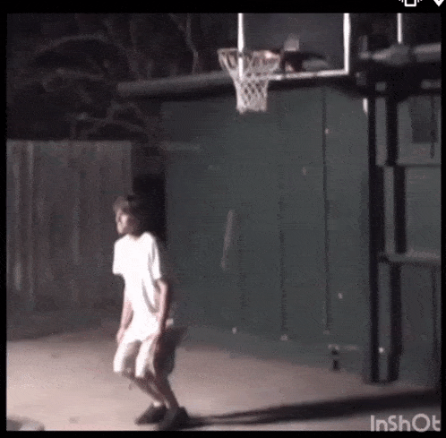 a boy is playing basketball in front of a basketball hoop that says inshot