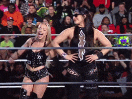 two women are in a wrestling ring and one has the letter x on her shirt