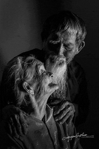 a man with a beard kisses an older woman on the cheek in a black and white photo taken by nguyen dinh phat
