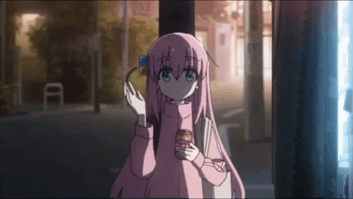 a girl with pink hair is holding a can of soda in her hands .