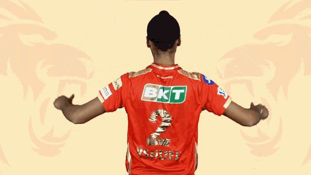 a man wearing a red shirt with bkt on it