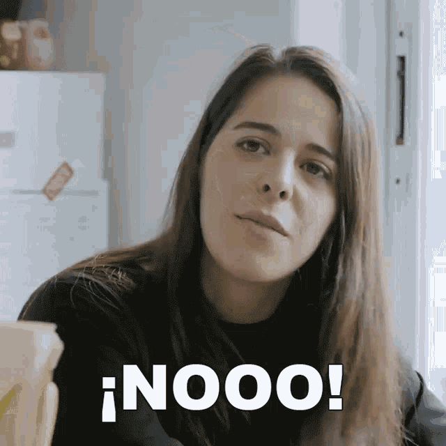 a woman with long hair says nooo in front of a refrigerator