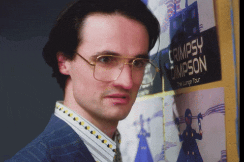 a man in glasses stands in front of a poster for cripsy campson
