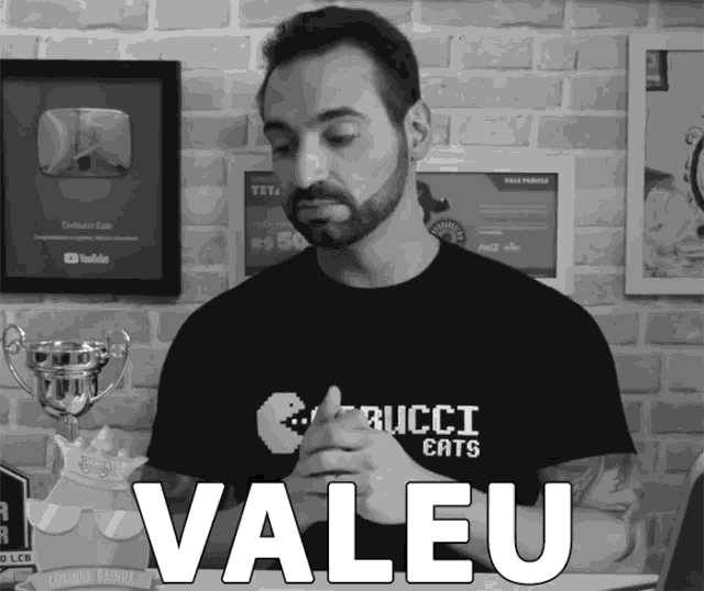 a man wearing a gucci eats t-shirt is giving a thumbs up
