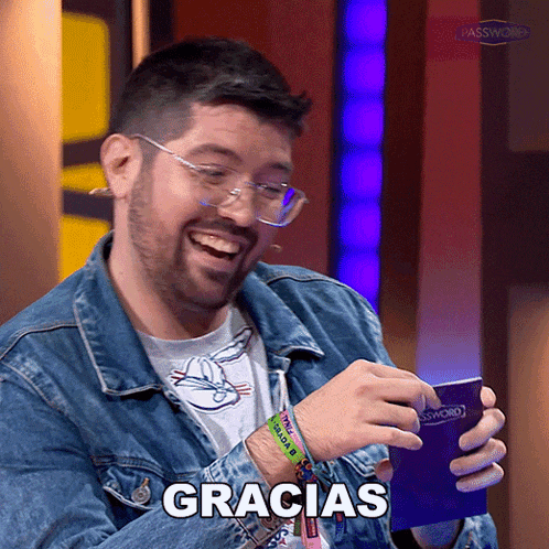 a man wearing glasses and a denim jacket is holding a wallet that says gracias on it