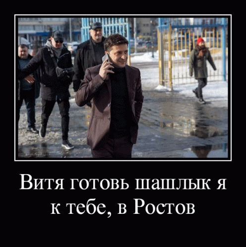 a man in a suit is talking on a cell phone while walking in the snow