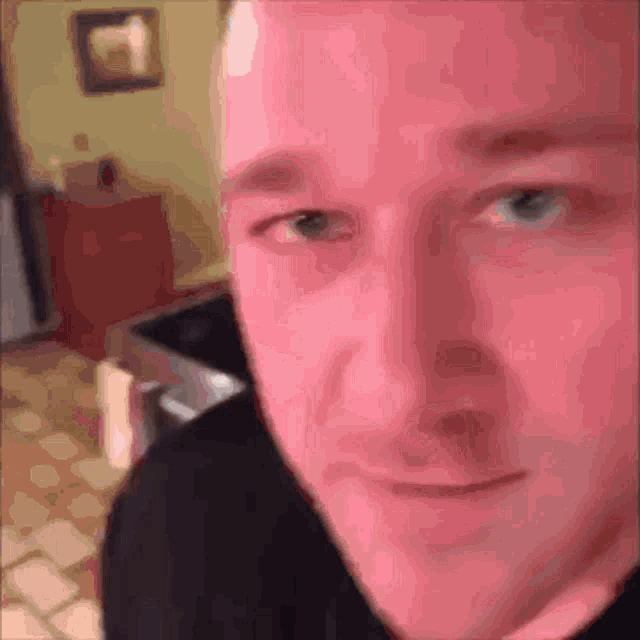 a close up of a man 's face with a black shirt