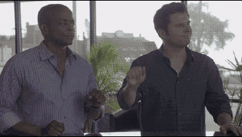 two men are standing next to each other in a room