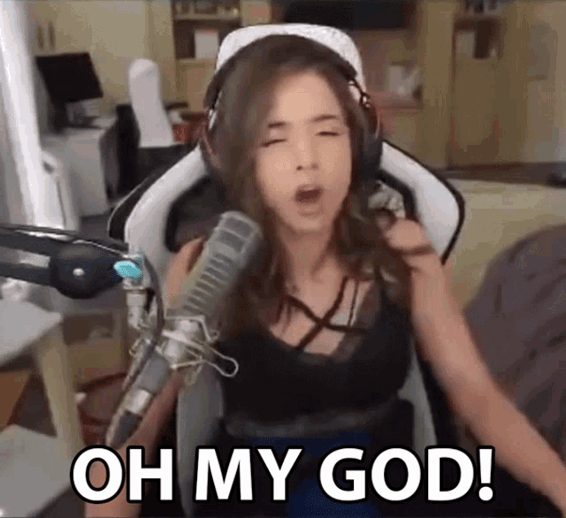 a woman wearing headphones is sitting in front of a microphone and says oh my god .