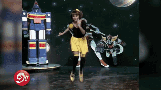 a woman is jumping in front of a robot with the letter d on the bottom