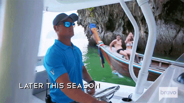 a man in a blue shirt is driving a boat with the words later this season below him