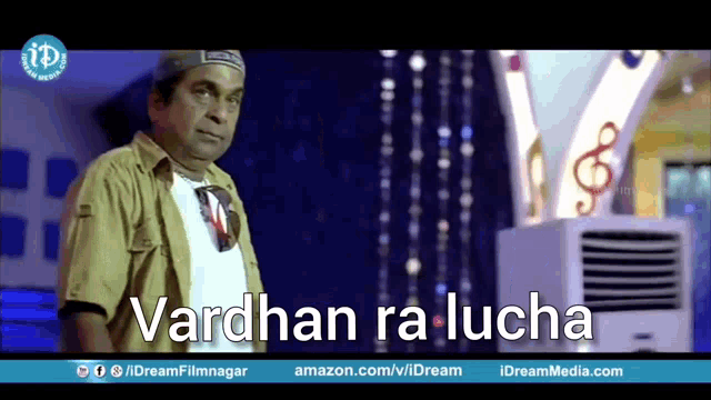 a man in a hat is standing in front of an air conditioner with the words vardhan ra lucha written on the screen .