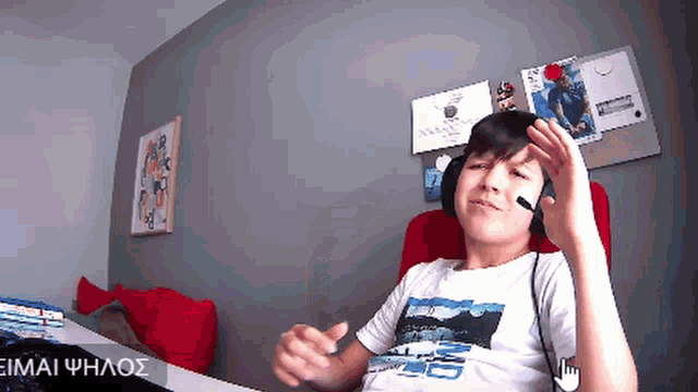 a boy wearing headphones and a t-shirt that says ' eimai phhaos ' on the bottom