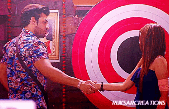 a man and a woman shake hands in front of a target that says ruksarcreations on it