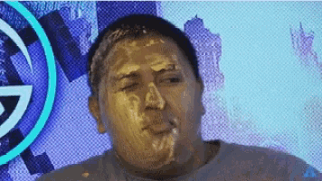 a man with gold paint on his face with a g on the background