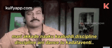 a man with a mustache is standing in front of a wall and says discipline ani dance lu kadatavernti .