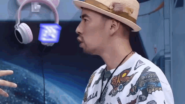 a man wearing a hat and headphones is talking to another person