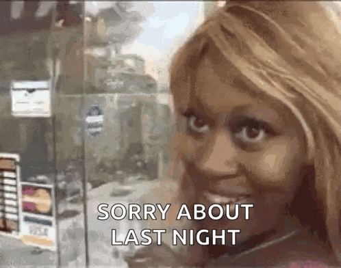 a woman is standing in front of a window with the words `` sorry about last night '' written on her face .