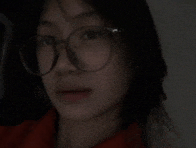 a woman wearing glasses and a red shirt is looking at the camera