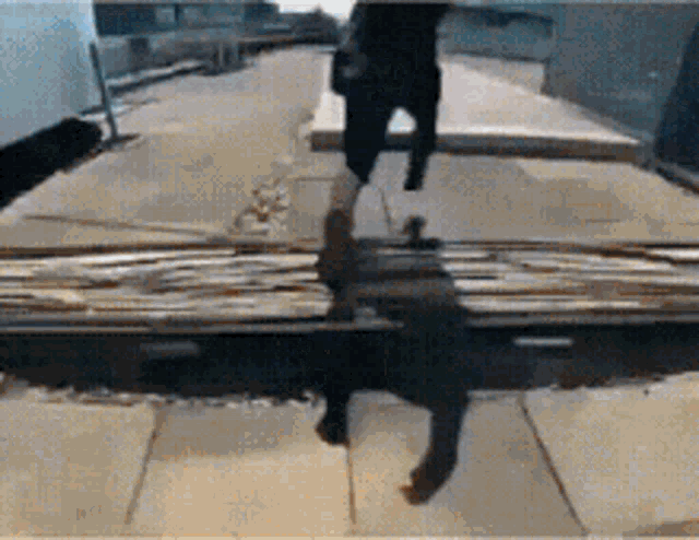 a person walking down a sidewalk with a shadow of a person on the ground