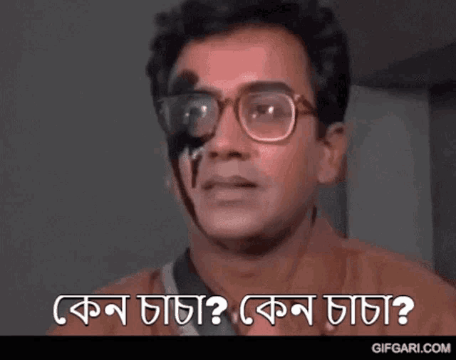 a man with glasses and a black spot on his face is smiling and asking a question in a foreign language .