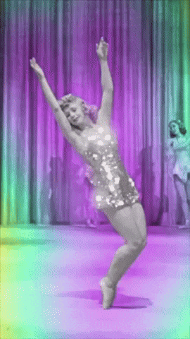a woman in a sequined dress is dancing in front of a purple curtain