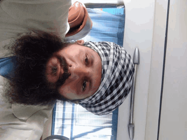 a man with a beard wearing a turban and a tie