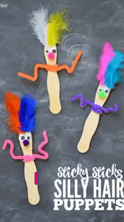 three popsicle stick puppets with colorful hair and pipe cleaners on them