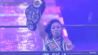 a woman in a wrestling ring holding a championship belt with the hashtag #njwd
