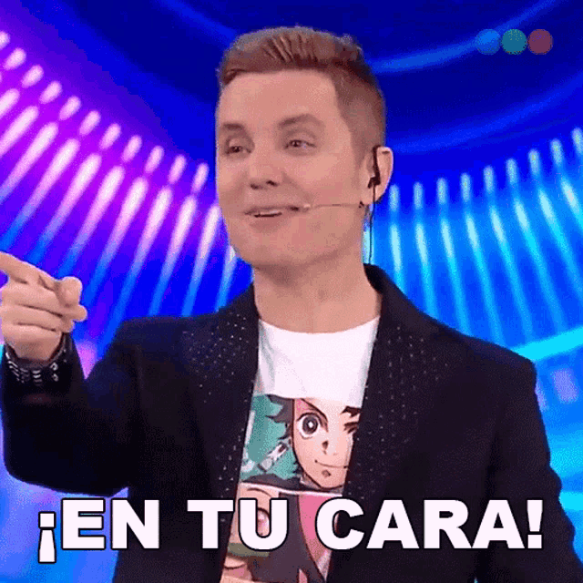 a man wearing a t-shirt that says en tu cara is pointing