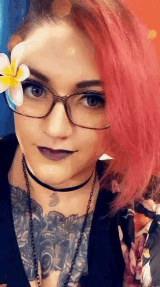 a woman with pink hair wearing glasses and a flower in her hair
