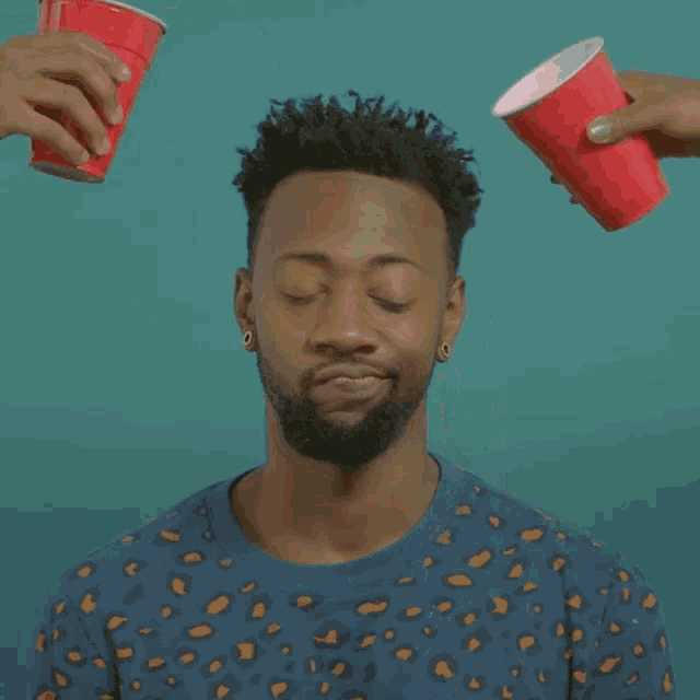 a man in a blue shirt is being poured with a cup of liquid