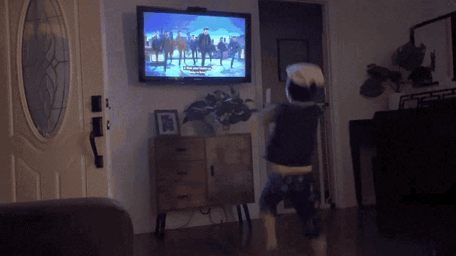 a child is playing a video game in front of a flat screen tv that says " when you dance " on the screen